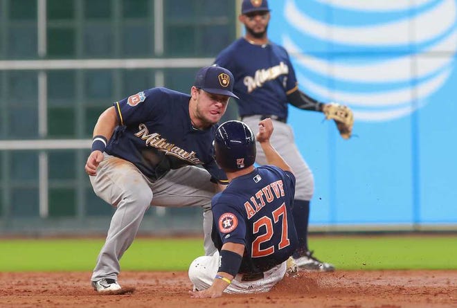 Houston Astros' Jose Altuve is caught stealing by Milwaukee Brewers second baseman Scooter Gennett during the third inning of an exhibition baseball game, Friday, April 1, 2016, in Houston. (AP Photo/Richard Carson)