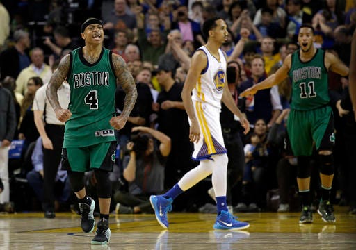 The Celtics' Isaiah Thomas (4) and Evan Turner (11) celebrate as time expires, and Golden State Warriors' Shaun Livingston (34) walks off the court at the end of Friday night's game. Boston won 109-106.