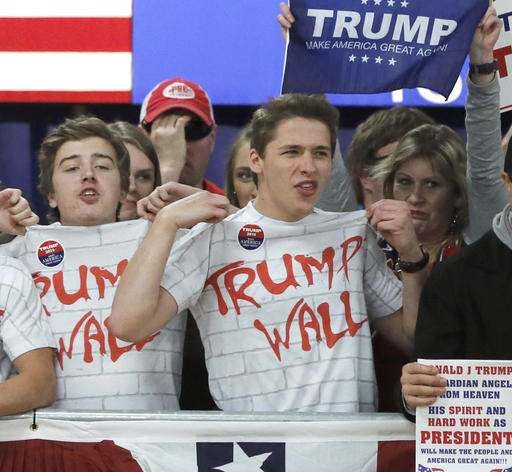 Supporters of Republican presidential candidate, Donald Trump, chant, Build That Wall, before a town hall Saturday, April 2, 2016, in Rothschild, Wis.