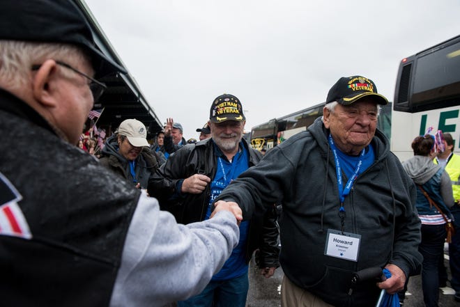 Guardian Doug Powers smiles as World War II veteran Howard Kraemer shakes hands with Charles Breiner from Claryville, during the Hudson Valley Honor Flight's 11th mission at Stewart International Airport in New Windsor, on Saturday. For a photo gallery, go to www.recordonline.com. Kelly Marsh/For the Times Herald-Record