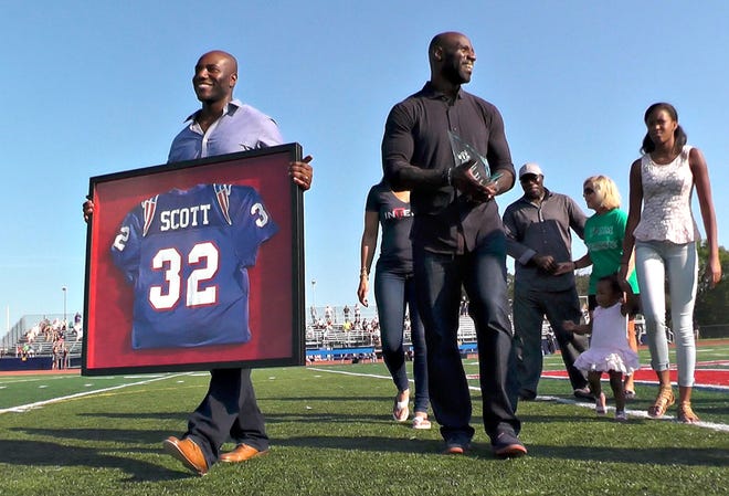 Former Buffalo Bills linebacker and former CB East football player Bryan Scott (right) walks with family members after he was honored at CB East in Buckingham Saturday, September 19, 2015 for being inducted into the CB East Hall of Fame.