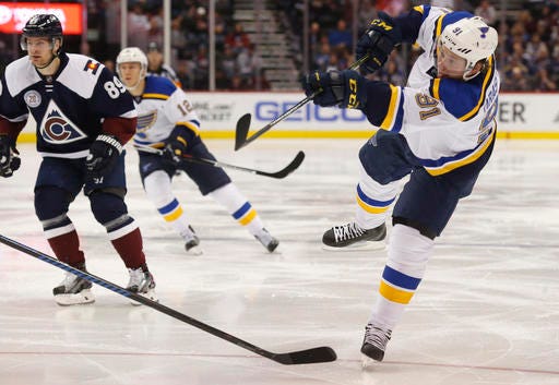 St. Louis Blues right wing Vladimir Tarasenko, right, of Russia, takes a shot in front of Colorado Avalanche left wing Mikkel Boedker, of Denmark, in the second period of an NHL hockey game, Sunday, April 3, 2016, in Denver.