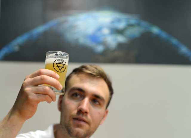 Eddie Siciliano, head brewer at 3rd Rock Brewing, lifts a glass of one of the Trenton brewery's new signature beers in the taproom on Friday.