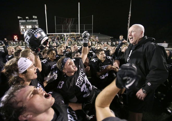 Perry football coach Keith Wakefield celebrates with his team following a victory during last season's playoff run to the state championship game.