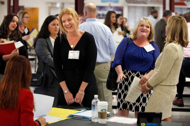 DARON.DEAN@STAUGUSTINE.COM Jennifer Smith talks with Cunningham Creek Elementary School Assistant Principal Marie Antoine during the St. Johns County School Districts spring teacher recruitment fair in the cafeteria at St. Augustine High School on April 2, 2016.