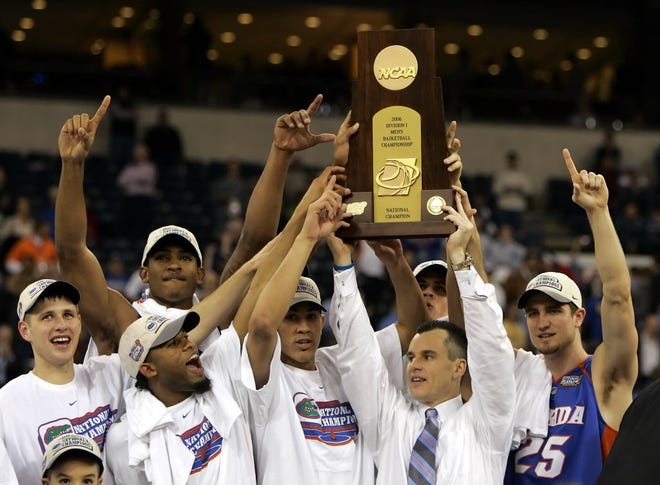 Caption: In this April 3, 2006, file photo, Florida players celebrate as coach BillyDonovan holds their NCAA trophy aloft after beating UCLA 73-57 in the national championship game in Indianapolis.
