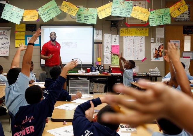 Students raise their hands to answer a question in a fifth-grade reading class taught by Michael Carter at KIPP Reach College Preparatory in Oklahoma City. [Photo by Sarah Phipps, The Oklahoman Archives]