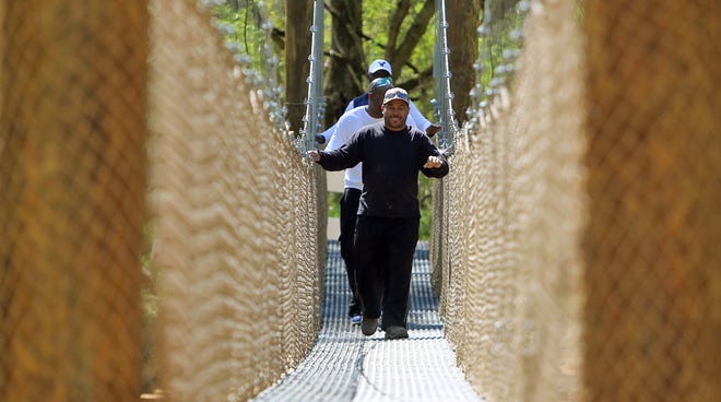 Brittany Randolph/The StarFrom front, Ray Ford, Anthony Potlow and Tyrone Beam cross the suspension bridge at the new trail in Shelby on Monday.