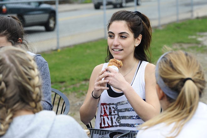 Bentley University student Kristina Ayanian, 18, of Burlington enjoys a donut ice cream cone served only at Pizzi Farms' opening day in Waltham on Friday, Apr. 1, 2016.

(Wicked Local Staff Photo/Brett Crawford)