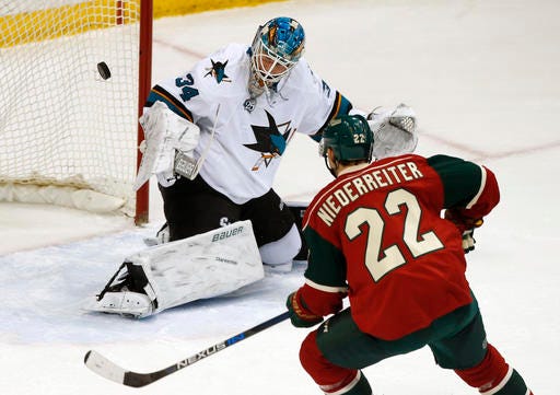 Minnesota Wild's Nino Niederreiter, right, of Switzerland, positions himself fora rebound as San Jose Sharks goalie James Reimer stops a shot in the first period of an NHL hockey game Tuesday, April 5, 2016, in St. Paul, Minn. (AP Photo/Jim Mone)