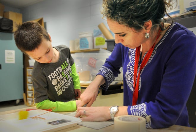 York Village Elementary School teacher Annette Slone helps a student cut out material for his design on creating a musical instrument in the makerspace room.

Photo by Deb Cram/Seacoastonline
