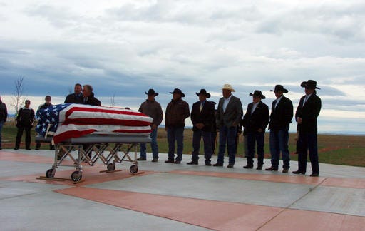 Pallbearers stand by the casket of Joe Medicine Crow during his funeral service at the Apsaalooke Veterans Cemetery near Crow Agency, Mont., Wednesday, April 6, 2016. Joe Medicine Crow was the Crow Tribe's last surviving war chief and a widely-renowned historian. Medicine Crow, who died April 3, 2016 at 102, was awarded the Presidential Medal of Freedom by President Barack Obama in 2009. (AP Photo/Matt Brown)