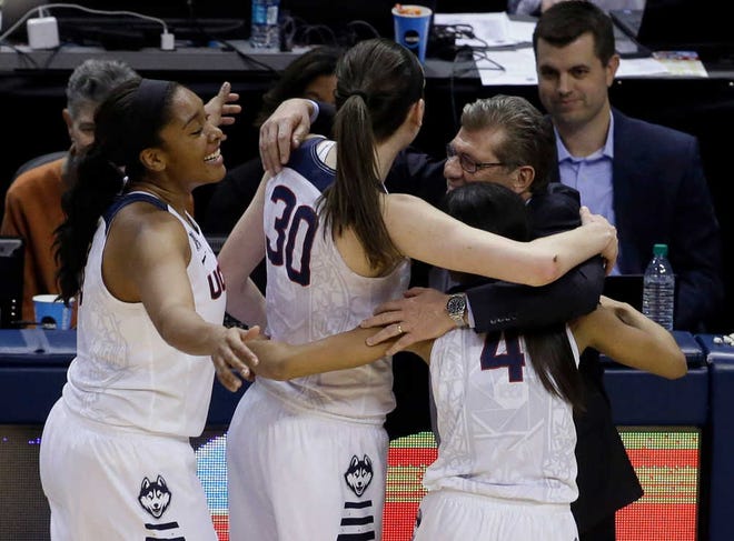 Connecticut head coach Geno Auriemma hugs Morgan Tuck (from left), Breanna Stewart and Moriah Jefferson on Tuesday. Those three players will enter the WNBA Draft, leaving a new core of Huskies to vie for the program's fifth consecutive national title.