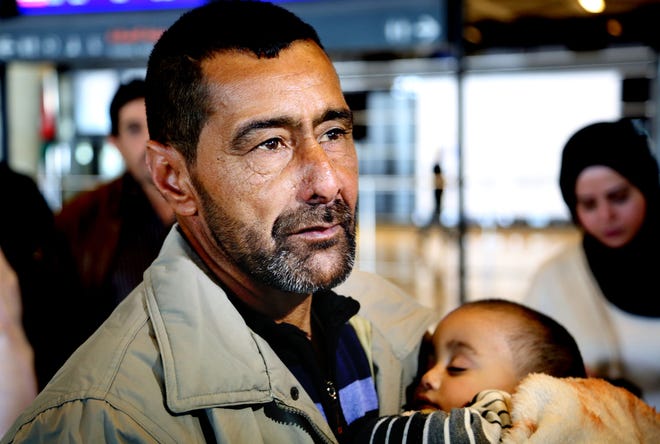 Syrian refugee Ahmad al-Abboud waits with his family at the International Airport of Amman, Jordan, Wednesday, April 6, 2016. The first Syrian family to be resettled to the U.S. under its speeded-up "surge operation" departed to the United States Wednesday from the Jordanian capital, Amman. Al-Abboud, who is being resettled with his wife and five children, said that although he is thankful to Jordan - where he has lived for three years after fleeing Syria's civil war - he is hopeful of finding a better life in the U.S. (AP Photo/Raad Adayleh)