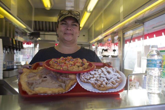 Kathy Ross showcases the elephant ear, the birthday cake funnel cake and the traditional funnel cake at Ross Concessions at the Lake County Fair.
