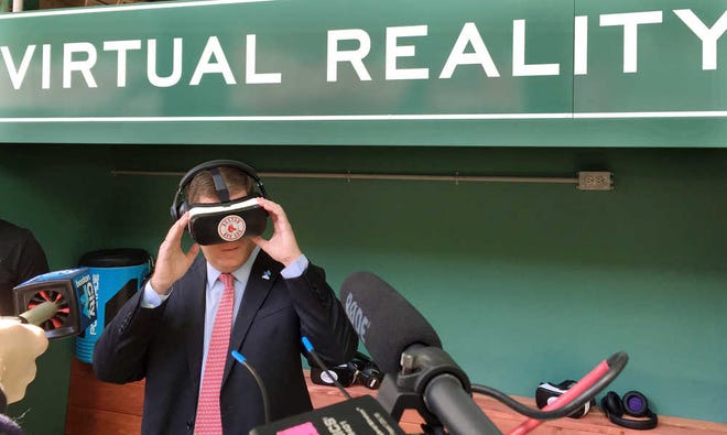 Boston Mayor Marty Walsh tries out a virtual reality device during a tour of the latest improvements at Fenway Park Friday, April 8, 2016, in Boston, in advance of Monday's Boston Red Sox home opener against the Baltimore Orioles. The free, two-minute virtual reality video shows scenes of batting practice and pitchers mound sessions from up close, with the viewer standing in the batters box or behind infielders as they take ground balls. Initially three dugout-themed booths will be stationed in the ballpark, each with several headsets. The club plans to also take the technology to schools and to other off-site events. (AP Photo/Jimmy Golen)