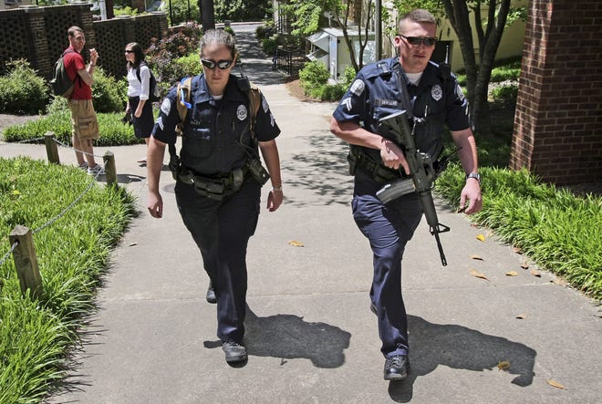 University of Georgia police officers patrol the campus in Athens, Ga., with a semi-automatic rifle during an April 27, 2009 search for professor George Zinkhan, suspected of killing his ex-wife and two others near campus two days earlier. Federal data and Associated Press interviews and requests for records reveal that at least 100 college police agencies have added rifles over the past decade. AP Photo/John Spink, Atlanta Journal-Constitution