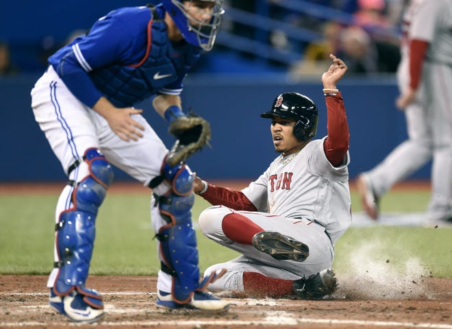Mookie Betts slides safely into home for a run during the sixth inning on Saturday.