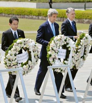 From left, Japan's Foreign Minister Fumio Kishida, U.S. Secretary of State John Kerry and Britain's Foreign Minister Philip Hammond carry wreath to offer at the cenotaph at Hiroshima Peace Memorial Park in Hiroshima, western Japan Monday, April 11, 2016. (Kyodo News via AP) JAPAN OUT, MANDATORY CREDIT