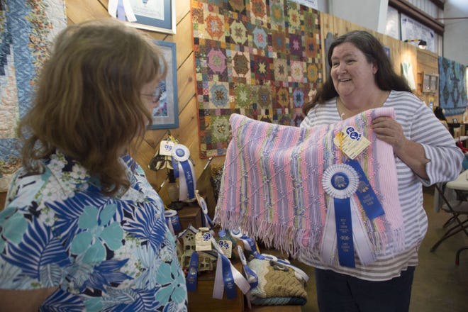 Carolyn Rutherford, left, talks to Joan Elliott about her afghan design and technique at the Lake County Fair.
