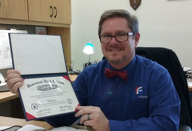 Flagler Schools information specialist Jason Wheeler holds up his high school diploma, which was found in a house being prepared for sale in Alabama. NEWS-JOURNAL/SHAUN RYAN