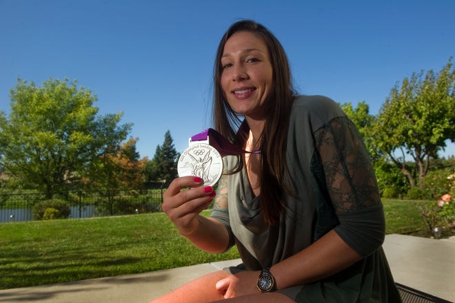 Stockton native Nicole Davis shows off her Olympic silver medal from the 2012 Games in London at her mother's home in Stockton. Davis spent 11 years on the U.S. National Team and recently retired from volleyball. She now works for a consulting firm and a non-profit in Southern California and is a volunteer assistant women's volleyball coach at USC. CLIFFORD OTO/RECORD FILE 2012