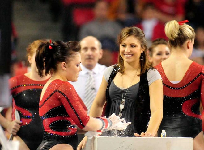 Volunteer coach Courtney Kupets, center, talks with Courtney McCool before her bar routine as Georgia beats NC State in gymnastics 196.800-193.900 at Stegeman Coliseum on Sunday, March 14, 2010 in Athens, Ga. (David Manning/david.manning@onlineathens.com)