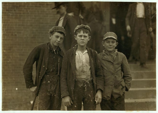 Thirteen-year-old John Moore, far right, and two unidentified boys are pictured as they leave work at the Loray Mill in Gastonia in 1908. (Photograph by Lewis Hine. Image courtesy of Library of Congress, Prints & Photographs Division,National Child Labor Committee Collection)