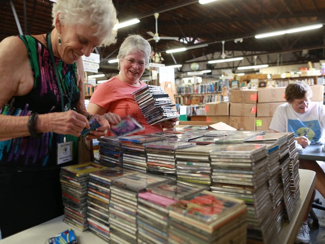 Volunteers organize and price stacks of compact disks for this weekend's Friends of the Library book sale at 430 N. Main St. in Gainesville.