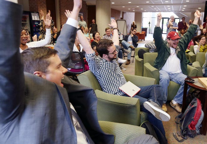 Carter Spires, center, a second year law student at the University of Alabama, and classmates cheer after he wins on an episode of Jeopardy while watching at the University of Alabama Law School Wednesday, April 13, 2016. Spires won Wednesday and goes on to compete Thursday. staff photo/Michelle Lepianka Carter