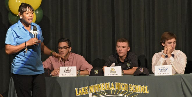 From left, Lake Minneola Principal Linda Shepherd-Miller, "Mama Hawk," introduces Emilio Alvarez, Colin Hornby and Tucker Rayburn at a signing ceremony at Lake Minneola High School on Wednesday.