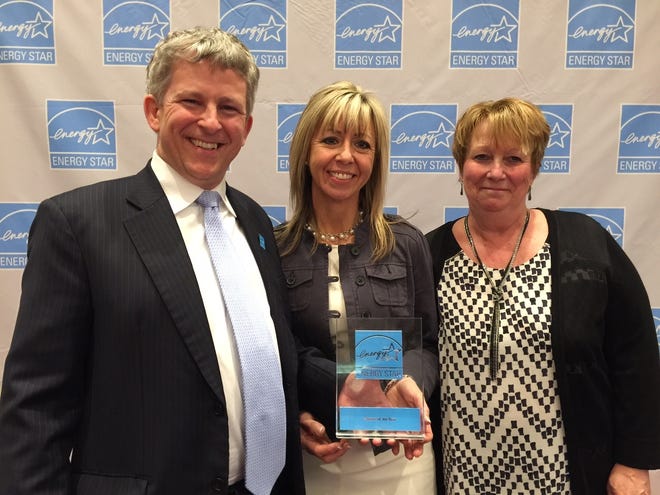 Jacob Moss, acting deputy director for the Climate Protection Partnerships Division of the Environmental Protection Agency, presents an Energy Star Partner of the Year to Karen Breen, center, and Lori Bachand of Chinburg Properties at a ceremony in Washington, D.C. Courtesy photo