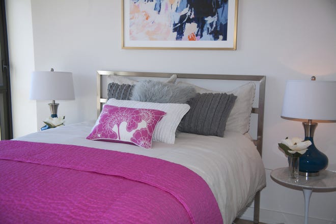 A piece of art with hints of pink and a hot pink coverlet adds a generous pop of color to this master bedroom. (Handout/TNS)