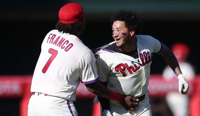 Philadelphia Phillies' Freddy Galvis, right, cheers with Philadelphia Phillies' Maikel Franco (7) after hitting the game-winning RBI allowing Andres Blanco to score on a pitch by Washington Nationals relief pitcher Jonathan Papelbon in the 10th inning of a baseball game, Sunday, April 17, 2016, in Philadelphia. The Phillies won 3-2. (AP Photo/Laurence Kesterson)