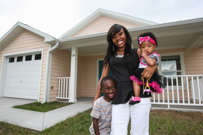 Joy Moore, 21, with her kids, Raheem Harris, 4, and Arianna Key, 6 months old, enjoy their new home in New Smyrna Beach. News-Journal / LOLA GOMEZ