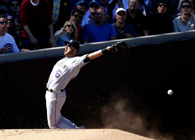 Colorado Rockies left fielder Ryan Reynolds can't catch a foul ball hit by Chicago Cubs' Dexter Fowler during the seventh inning of a baseball game Saturday, April 16, 2016, in Chicago. (AP Photo/Nam Y. Huh)
