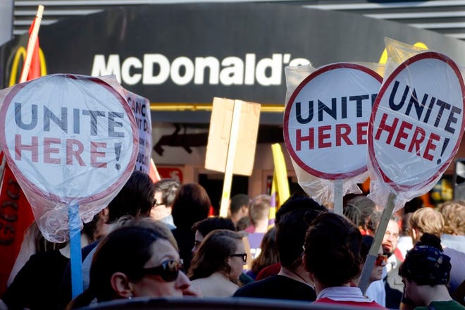 Supporters for a $15-an-hour minimum wage wave their signs in front of a McDonald's restaurant. The movement has reached Florida, though bills seeking to raise the minimum wage have not gained traction.