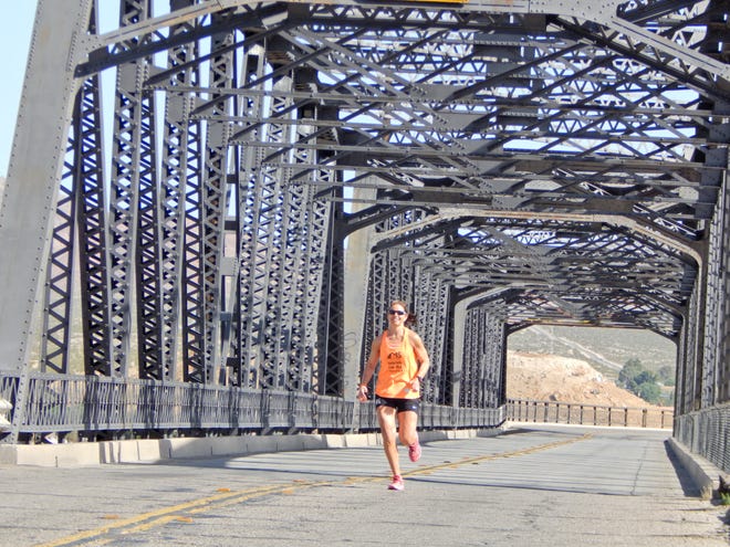Melissa Schmidt runs across the First Avenue Bridge on Friday during the 3,000 mile Relay Run Across America. Mike Lamb, Desert Dispatch.