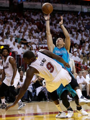 Charlotte Hornets guard Jeremy Lin (7) shoots as Miami Heat forward Luol Deng (9) falls to the court during the first half of an NBA basketball game, Sunday, April 17, 2016, in Miami. Lin was called for an offensive foul on the play. (AP Photo/Lynne Sladky)