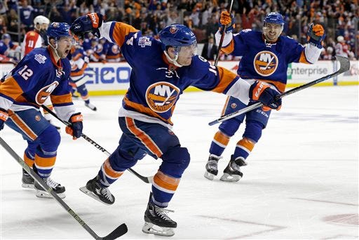 New York Islanders defenseman Thomas Hickey (14) celebrates after scoring the game-winning goal during overtime in Game 3 of an NHL hockey first-round Stanley Cup playoff series against the Florida Panthers, Sunday, April 17, 2016, in New York. The Islanders won 4-3. (AP Photo/Adam Hunger)