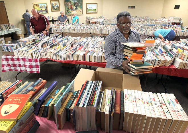 Timothy Toms unpacks books in preparation for the Annual Friends of the Library Annual Book Sale which begins at 9 a.m. Wednesday and runs through Saturday at the Gaston County Public Library Main Branch on Garrison Boulevard in Gastonia. JOHN CLARK/THE GAZETTE