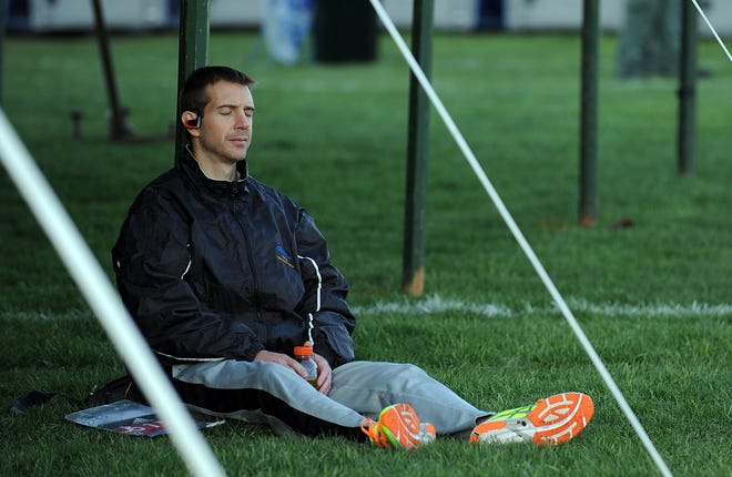 Tony Romanelli, Jr. of Milford listens to music after arriving very early to the Athletes' Village at Hopkinton Middle School.

Daily News and Wicked Local Staff Photo/ Allan Jung