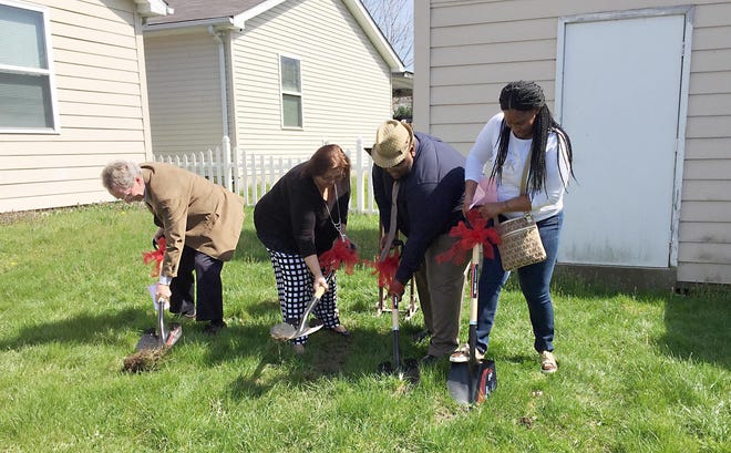 Pictured from left to right at a ground-breaking ceremony are Greater Erie Habitat for Humanity board members Jim Haas and Michelle Kelley, both of Millcreek Township, and Habitat family partner Scot Galloway and upcoming Habitat home recipient Ebony Gambill, both of Erie, at Gambill's future property, 2504 McClelland Ave., on April 18 in Erie. This Habitat project will take a different approach, according to Habitat officials: workers at the property will build an addition onto an already-built house, seen at left, which is owned by Habitat. Work is expected to begin in late April. DANA MASSING/