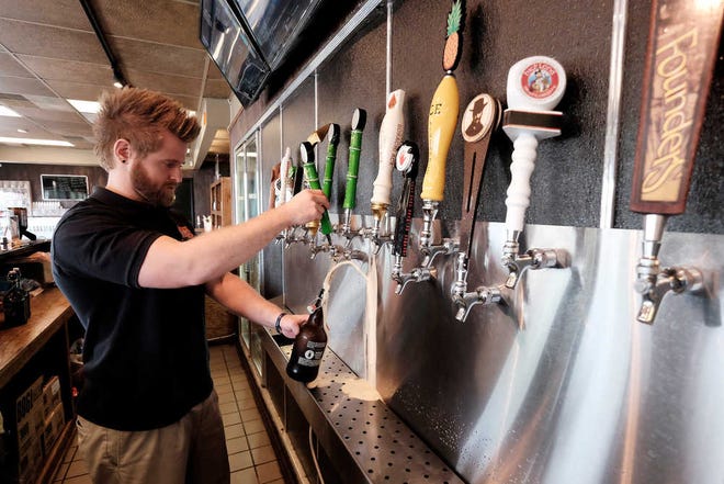 Derick Howard fills up a howler with RiverWatch Brewery's Route 104 at Tip Top Taps in Evans. Three of the brewery's products were available there and at other locations.