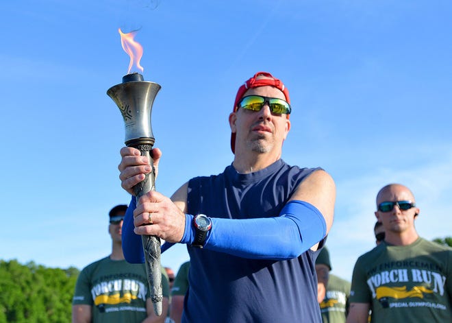Jason Ash is first to carry the flame as Sumter County law enforcement officers take part in a Torch Run to benefit Special Olympics athletes.