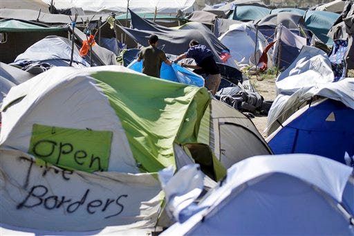 Two men set a tent at a camp for migrants and refugees at the northern Greek border point of Idomeni, Greece, Wednesday, April 20, 2016. Human Rights Watch says the initial round of deportations of migrants from Greece to Turkey under a new European Union-Turkey deal were "rushed, chaotic and violated the rights of those deported." (AP Photo/Gregorio Borgia)