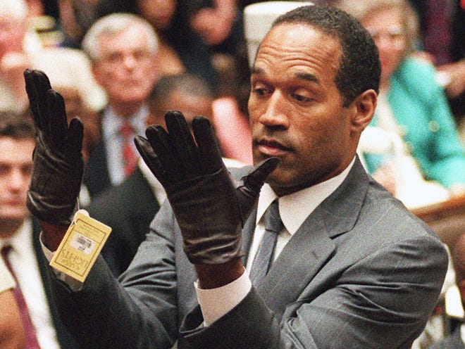 O.J. Simpson is pictured in 1995 holding up his hands before the jury after putting on a new pair of gloves similar to the infamous bloody gloves during his double-murder trial in Los Angeles.