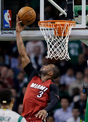Miami Heat guard Dwyane Wade (3) puts up a reverse layup against the Boston Celtics in the second half of an NBA basketball game, Wednesday, April 13, 2016, in Boston. (AP Photo/Elise Amendola)