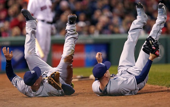Tampa Bay Rays starting pitcher Drew Smyly, right, hangs on to the ball after colliding with first baseman Logan Morrison while catching a foul ball by Boston Red Sox's Chris Young during the eighth inning of a baseball game Tuesday, April 19, 2016, in Boston.
