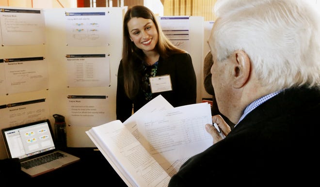 Tiffany A. Ferreira, left, a graduate student at UMass Dartmouth, explains her research in the onset and progression of Alzheimer's disease to Donald Wood, retired professor. MIKE VALERI/THE STANDARD-TIMES/SCMG